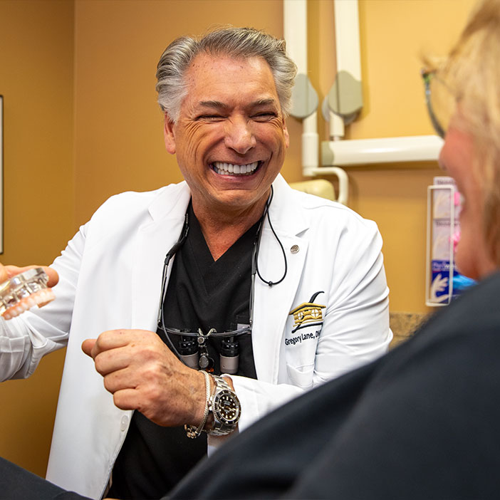 Doctor holding up moel of dental implants