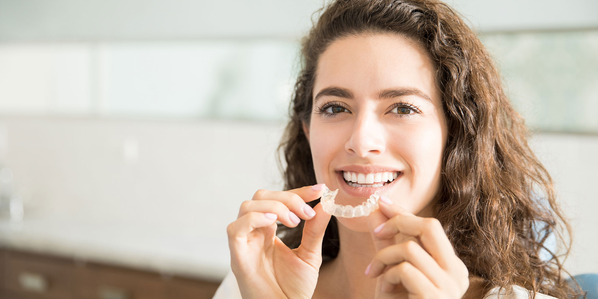 woman putting a invisalign in her mouth